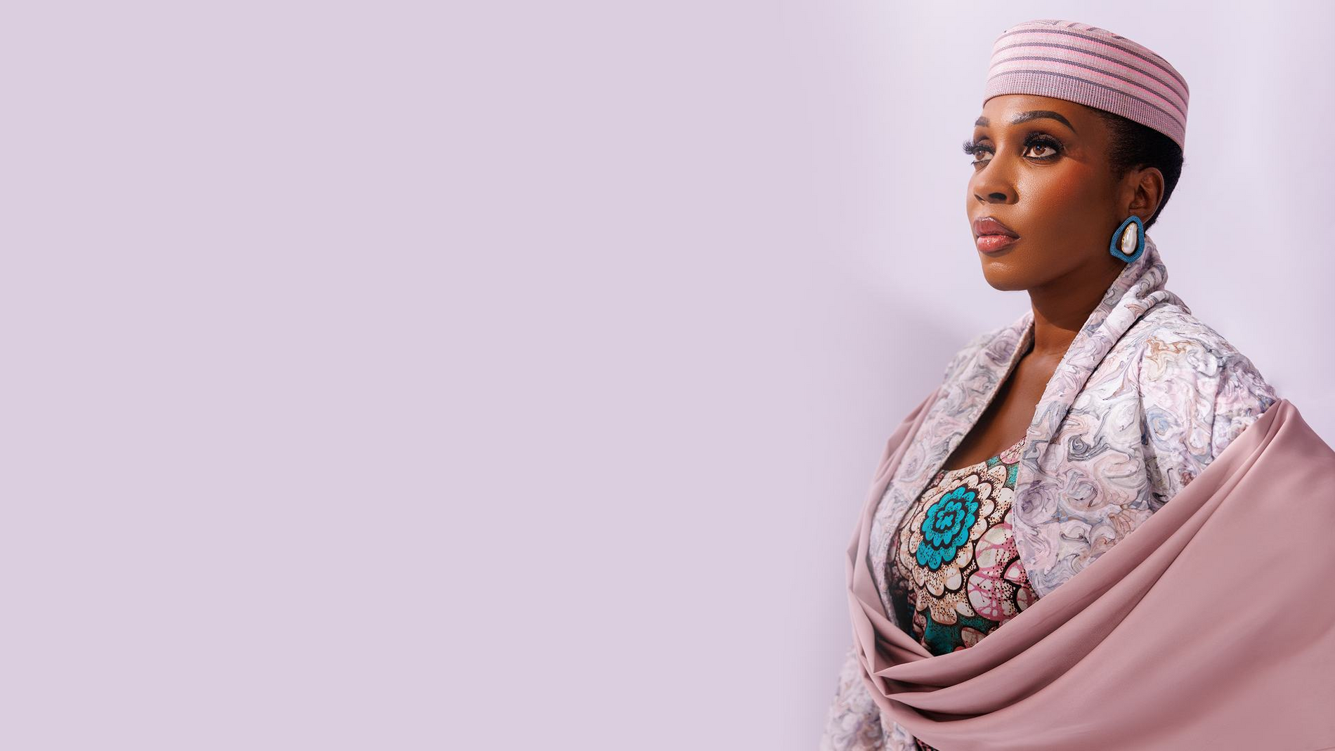 Founder of MAYYISAH wearing a pink cap and draped textile