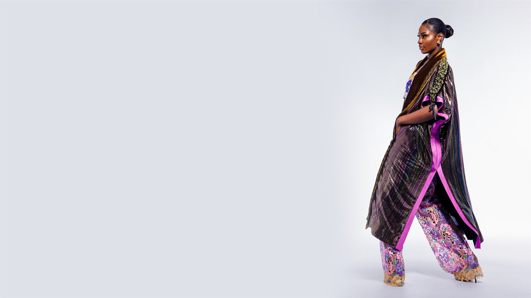 MAYYISAH model in a dark embroidered wrap on a studio background